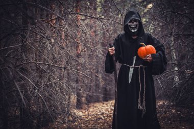İblis kostümlü korkunç kadın ve ormanda elinde balkabağı tutan korkunç kadın. Vampir hayalet insanlar, Mutlu Cadılar Bayramı konsepti