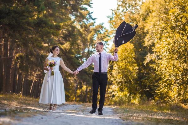 Recém-casados estão andando no parque verde — Fotografia de Stock