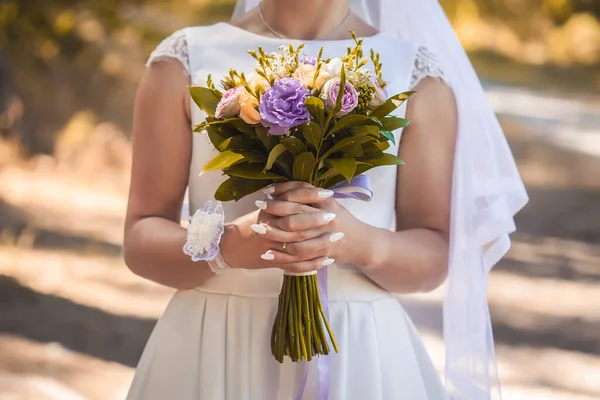 秋の紅葉を背景に花嫁が花を手に. — ストック写真