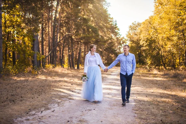 Recém-casados estão caminhando na floresta de pinheiro verde — Fotografia de Stock