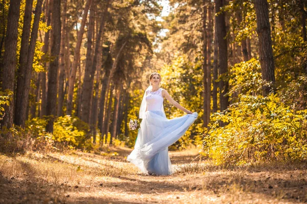 Noiva com um buquê está andando no parque verde — Fotografia de Stock