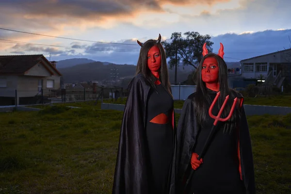 Dos mujeres jóvenes disfrazadas de diablo en Halloween en España —  Fotos de Stock