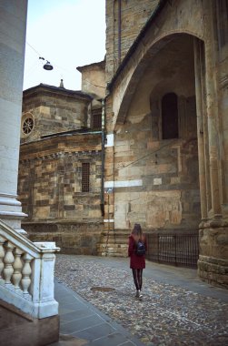 Genç bir kadın Bologna merkezinin önünden geçiyor.