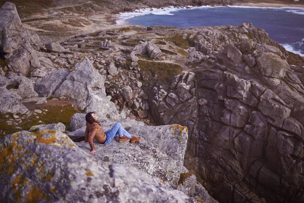 Mujer sentada en un acantilado cerca de Baronha Castro en Galicia —  Fotos de Stock