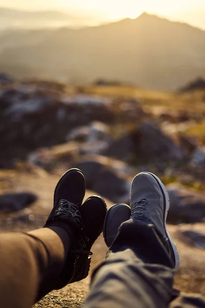 Detalle de dos pares de pies frente a un paisaje desenfocado al atardecer —  Fotos de Stock