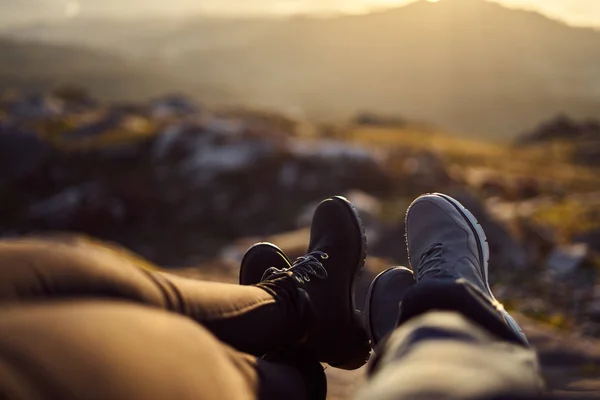 Detalle de dos pares de pies frente a un paisaje desenfocado al atardecer —  Fotos de Stock