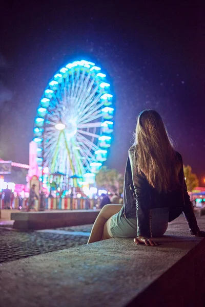 Mladá žena uvažuje o tom, že v noci bude mít na sobě Ferrisův volant — Stock fotografie