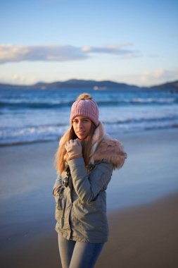 Genç kadın kışın sahilde yürüyüşe çıkıyor