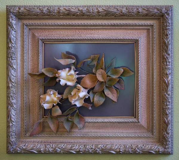 Bir çerçeve üzerinde porselen çiçekler