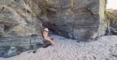 Galiçya, İspanya kayalıklar ile bir plajda yaz zevk bir şapka ile genç kadın