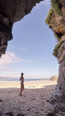 Galiçya, İspanya'da kayalardan yapılmış bir mağara düşünen genç kadın