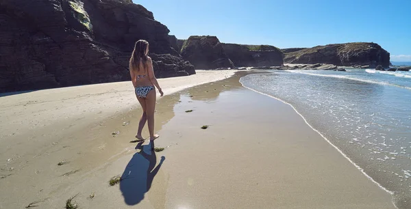 Junge Frau am Strand mit Klippen in Galicien, Spanien — Stockfoto