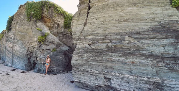 Mujer joven con sombrero disfrutando del verano en una playa con acantilados en Galicia, España —  Fotos de Stock