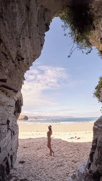 Mujer joven contemplando una cueva hecha de rocas en Galicia, España —  Fotos de Stock