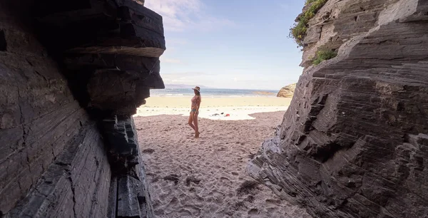 Mujer joven contemplando una cueva hecha de rocas en Galicia, España —  Fotos de Stock