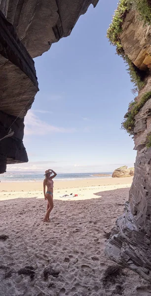 Mujer joven contemplando una cueva hecha de rocas en Galicia, España —  Fotos de Stock