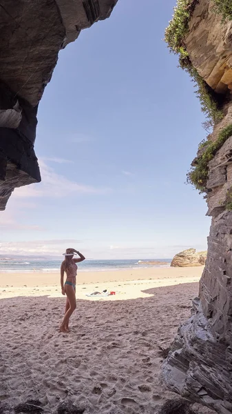 Mujer joven contemplando una cueva hecha de rocas en Galicia, España —  Fotos de Stock