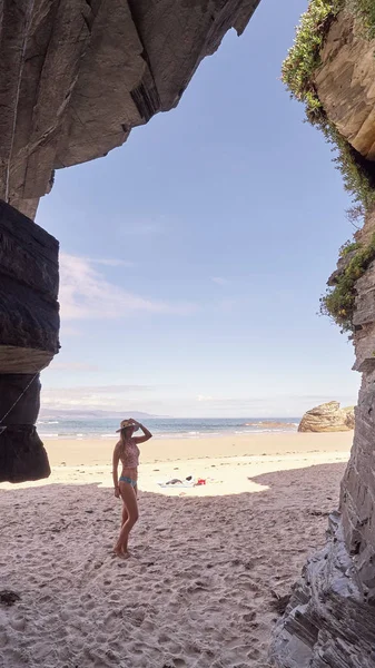 Mujer joven contemplando una cueva hecha de rocas en Galicia, España —  Fotos de Stock