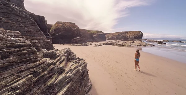 Mujer joven caminando en una playa en Galicia —  Fotos de Stock