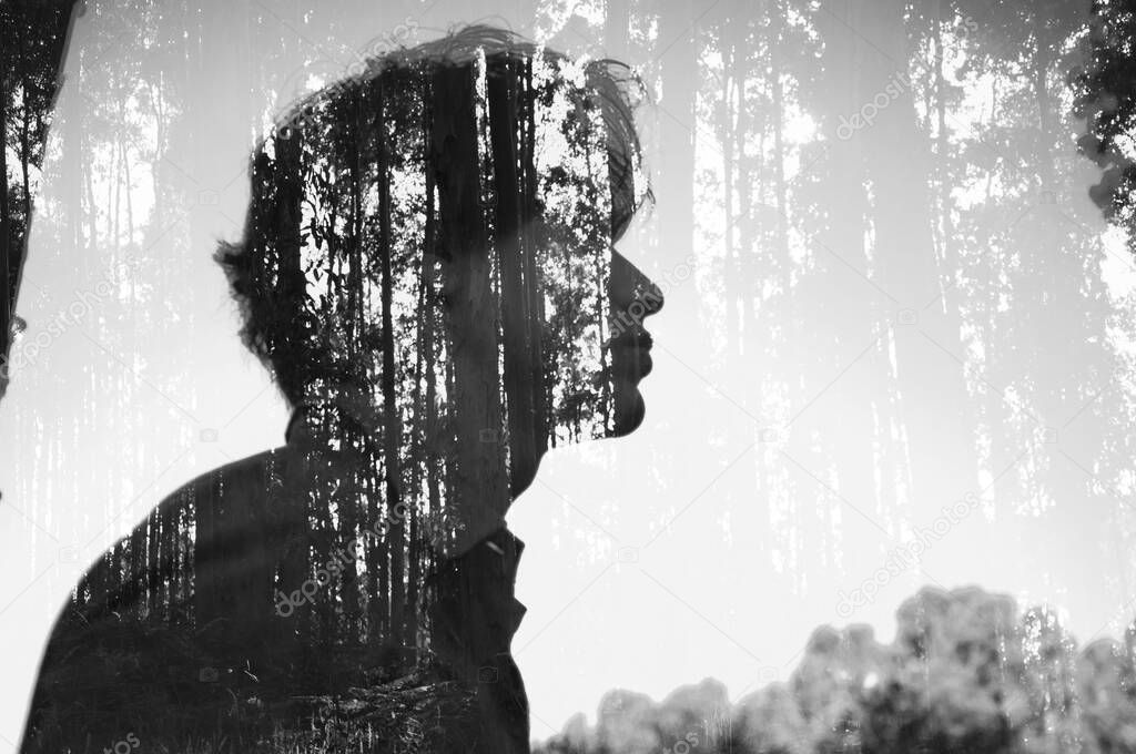 Double exposure of a man and a forest