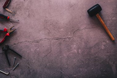 Çatlak bir beton arkaplana karşı bazı araçların düz yatıyordu