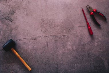 Çatlak bir beton arkaplana karşı bazı araçların düz yatıyordu