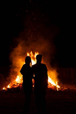 Dev bir şenlik ateşinin önündeki bir çiftin silueti, tipik bir İspanyol yaz gündönümü kutlaması, buna San Juan gecesi ya da Aziz John gecesi diyor.