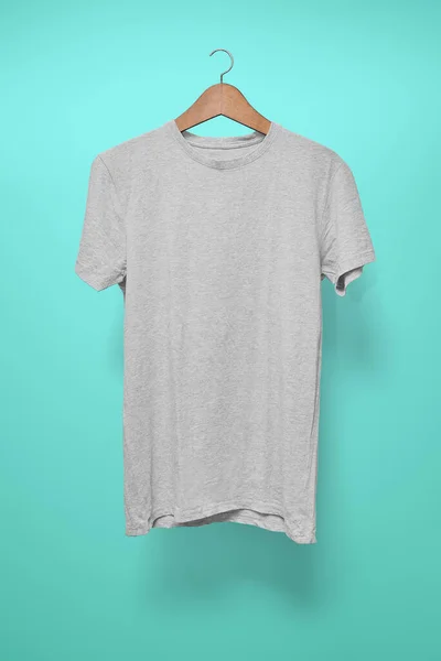 Grey T-Shirt on a hanger against a turquoise background