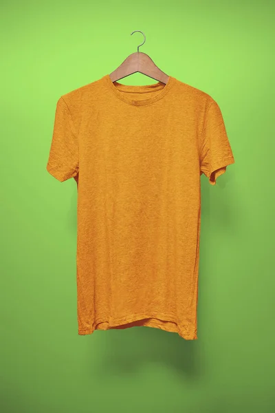 Orange Shirt Hängare Mot Grön Bakgrund — Stockfoto