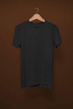 Kahverengi arka planda asılı siyah tişört