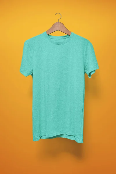 Turquoise T-Shirt on a hanger against an orange background