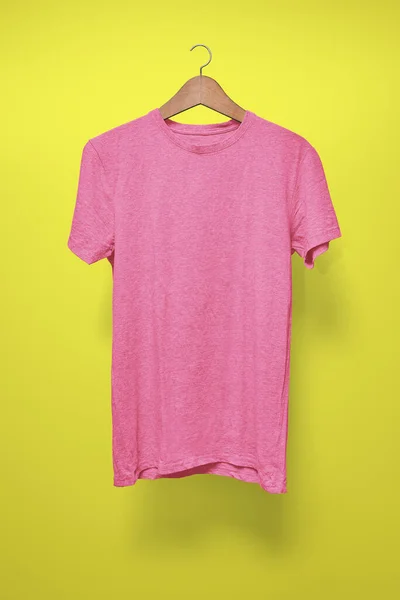 Pink T-Shirt on a hanger against a yellow background