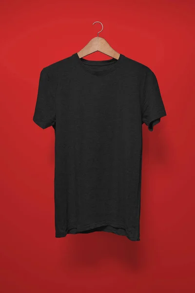 红色背景的衣架上的黑色T恤 — 图库照片