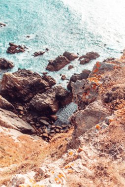 İspanya, Galiçya 'da yüksek bir uçurumun dibindeki deniz kenarındaki kayaların detayları.