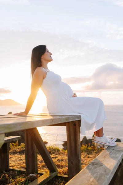 Portret Van Een Zwangere Vrouw Tegen Een Oceaanlandschap Bij Zonsondergang — Stockfoto