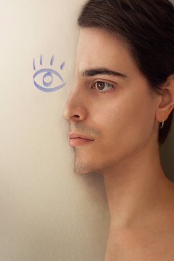 Yarı gömülü bir adamın portresi. Duvarın ortasında, üzerinde bir göz resmi olan bir adam.