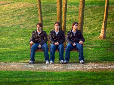 Three clones of the same man sitting on a bench clipart