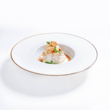 Balık, deniz tarağı ve sebzeli lüks bir yemek. Yüksek kaliteli yiyecekler, beyaz gölgeli..