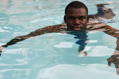 Havuzda poz veren genç yakışıklı adam.