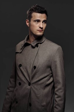 Stüdyo çekimi. Poz veren genç yakışıklı adamın portresi.