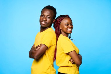 Stüdyoda mavi arka planda poz veren genç ve güzel bir çift