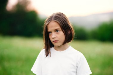Genç tatlı kız çayırda eğleniyor.