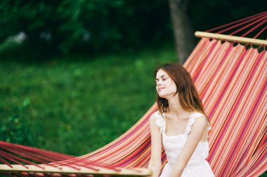 Genç ve güzel bir kadın hamakta dinleniyor. 
