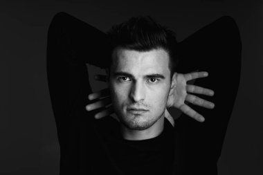 Stüdyo çekimi. Poz veren genç yakışıklı adamın portresi.