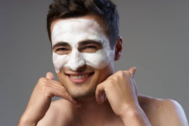 Genç adam yüz maskesi takıyor. 