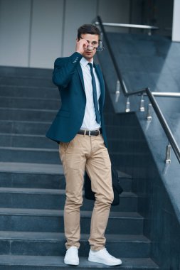 Sokakta çanta taşıyan genç bir iş adamı.