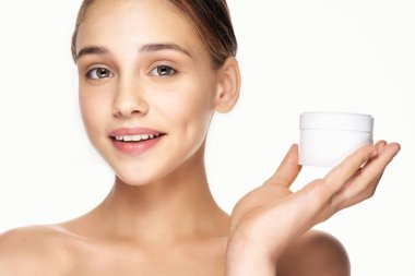 Genç ve güzel bir kadın krem tutuyor. 