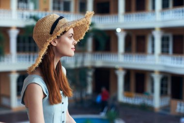   Tropik tatil köyünde hasır şapkalı genç bir kadın. 
