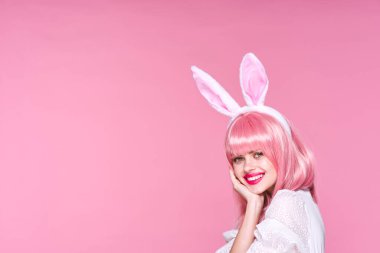 Tavşan kulaklı genç bir kadın stüdyoda poz veriyor. 