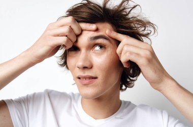 Stüdyoda sivilceli genç yakışıklı bir adam.